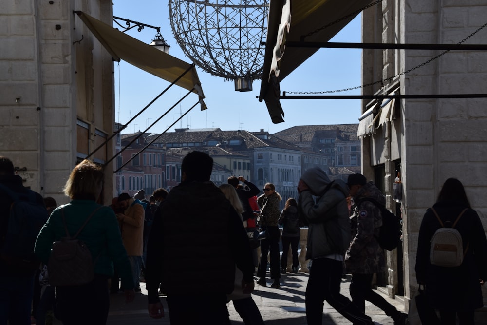 Un grupo de personas caminando por una calle junto a edificios altos