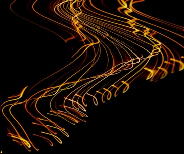 a long exposure photo of yellow lines on a black background