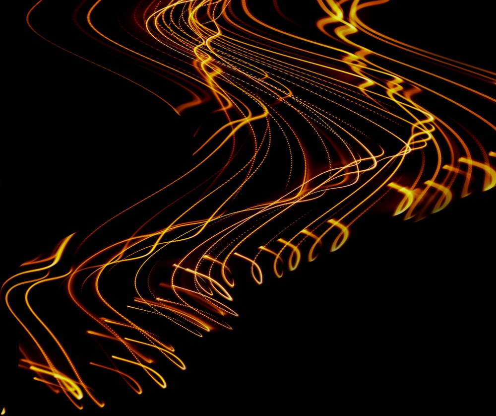 a long exposure photo of yellow lines on a black background