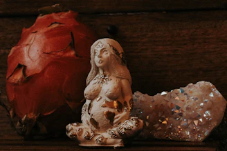 a statue of a woman sitting next to a rock