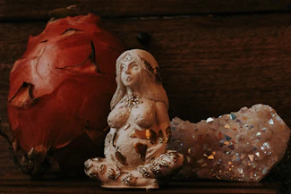 a statue of a woman sitting next to a rock