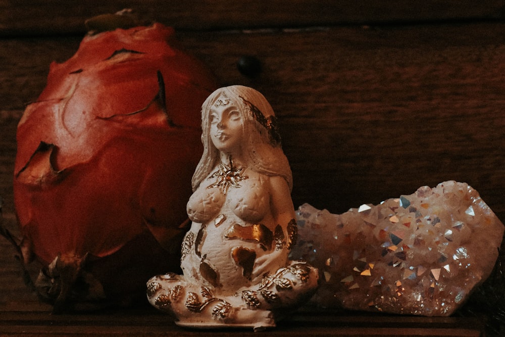 a statue of a woman sitting next to a rock