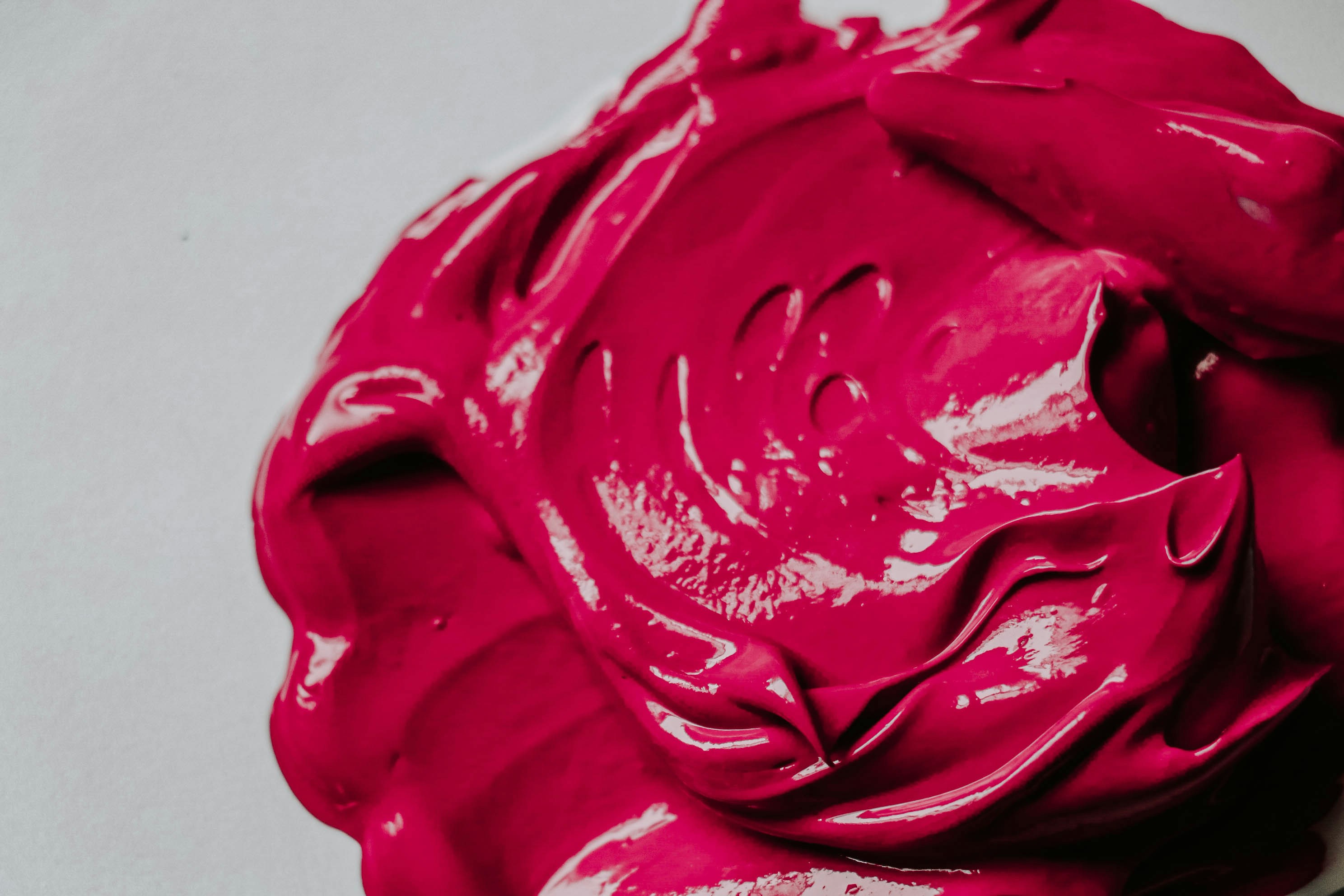 a close up of a pink substance on a white surface