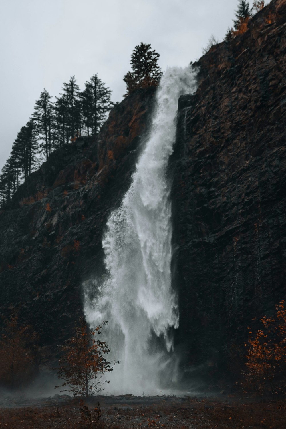 a very tall waterfall in the middle of a forest