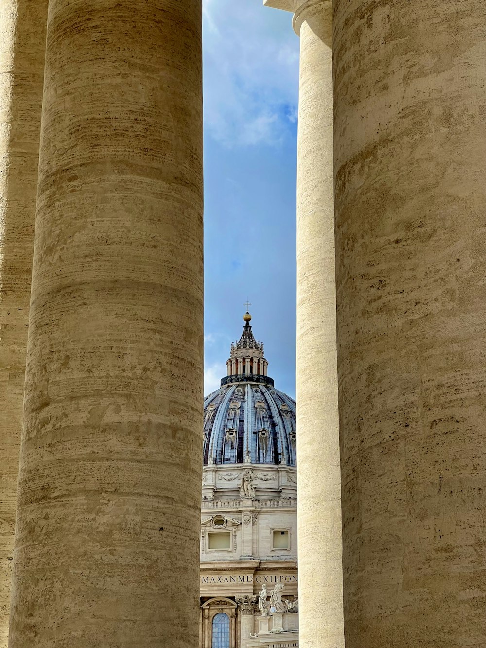 a view of a building through some pillars