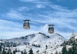 a couple of ski lifts above a snow covered mountain