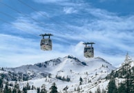 a couple of ski lifts above a snow covered mountain