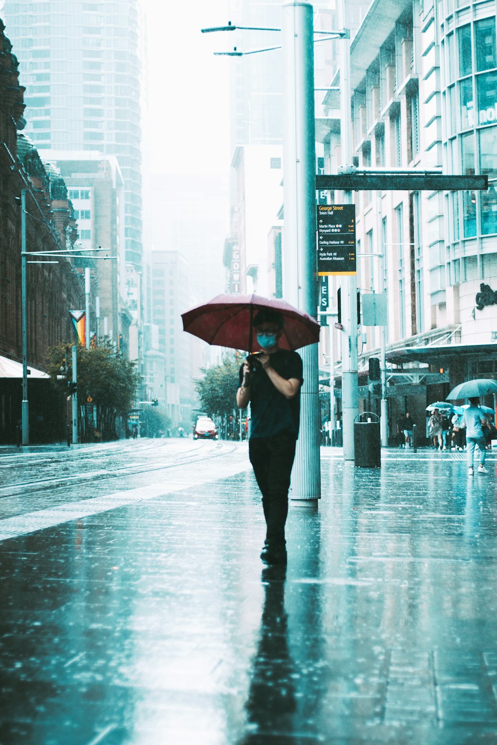 a woman walking down a street holding an umbrella