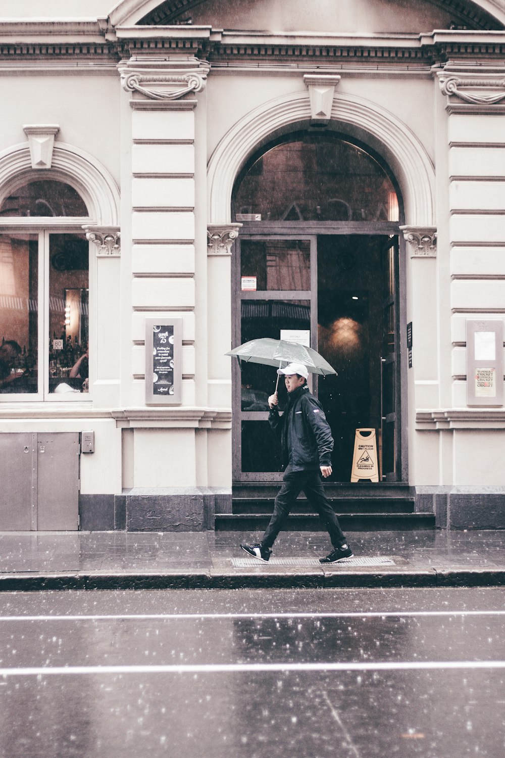 a man walking down a street holding an umbrella