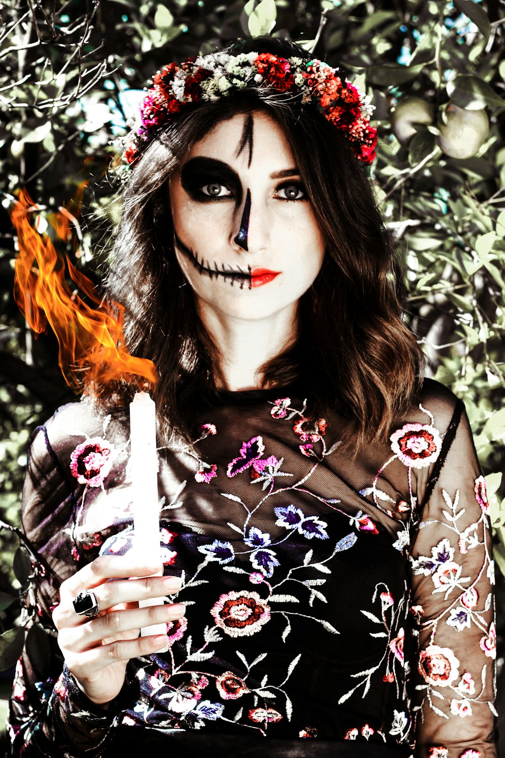 a woman wearing a skeleton makeup holding a cigarette