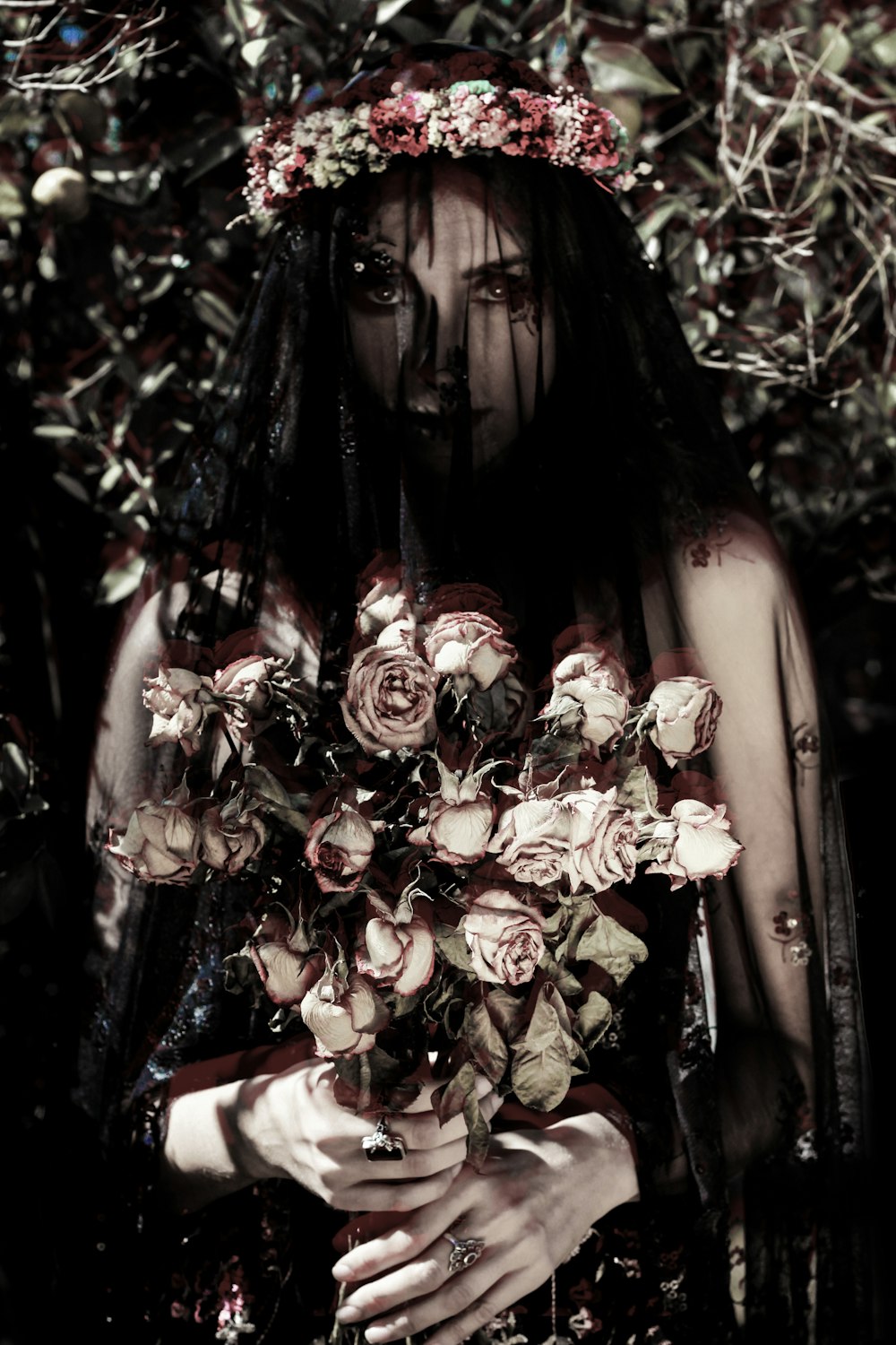 a woman in a black dress holding a bouquet of roses