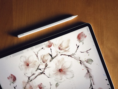 a tablet with a painting of flowers on it