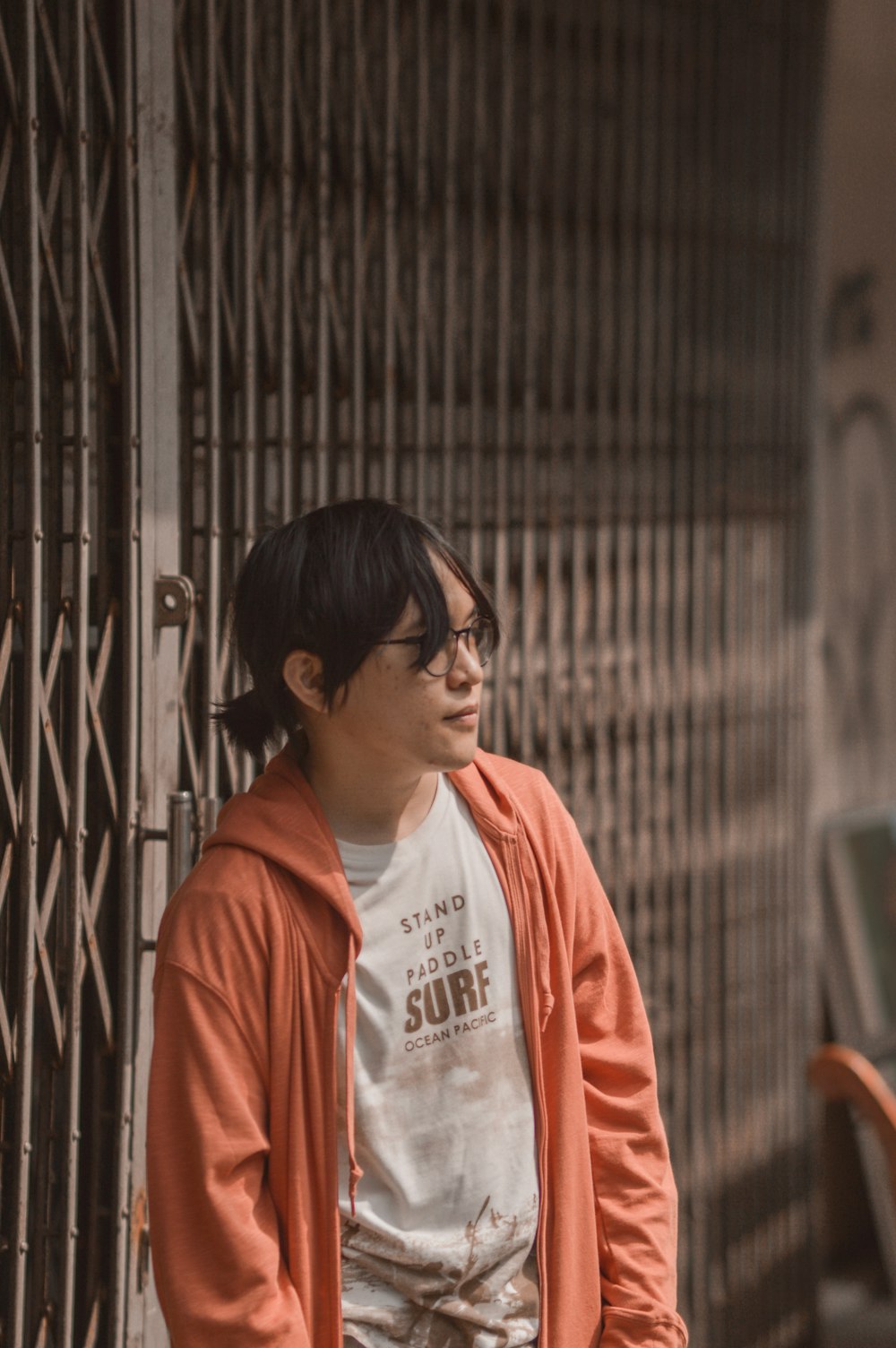 a man standing next to a metal fence