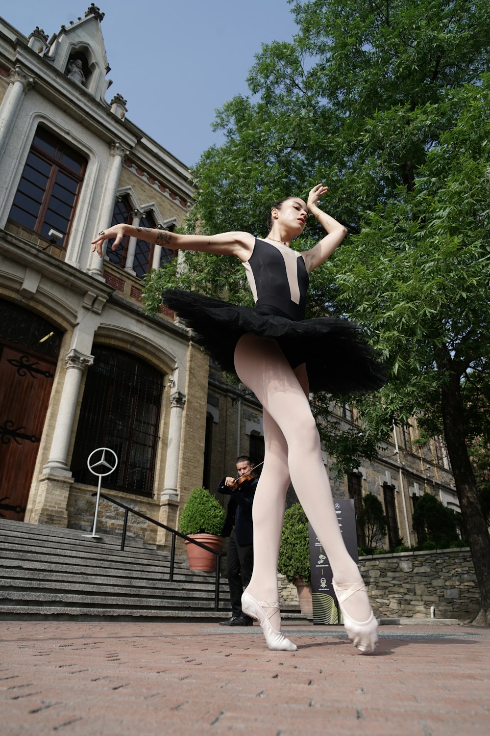 a ballerina in a black leotard and white tights
