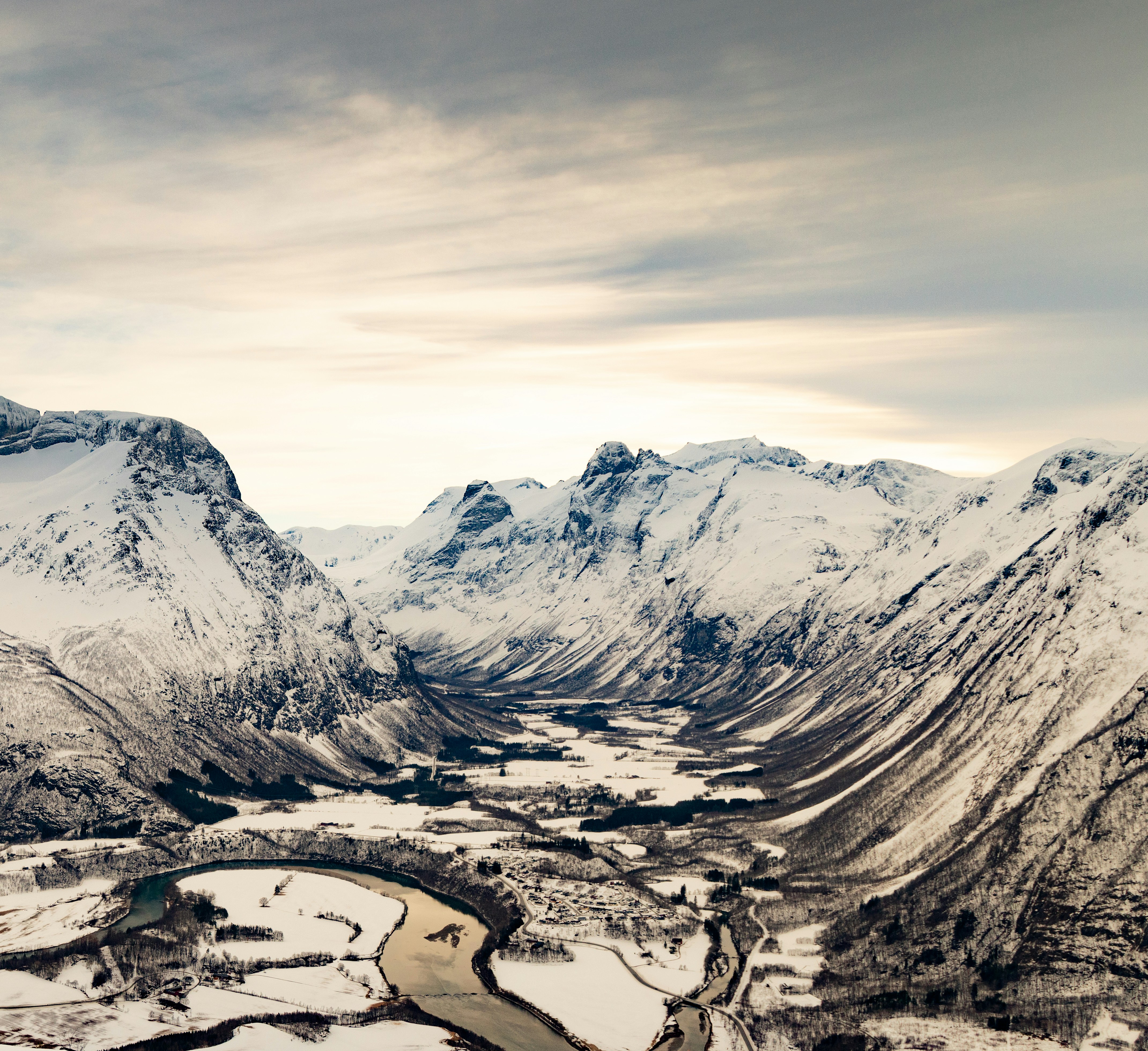 a snowy mountain range with a river running through it