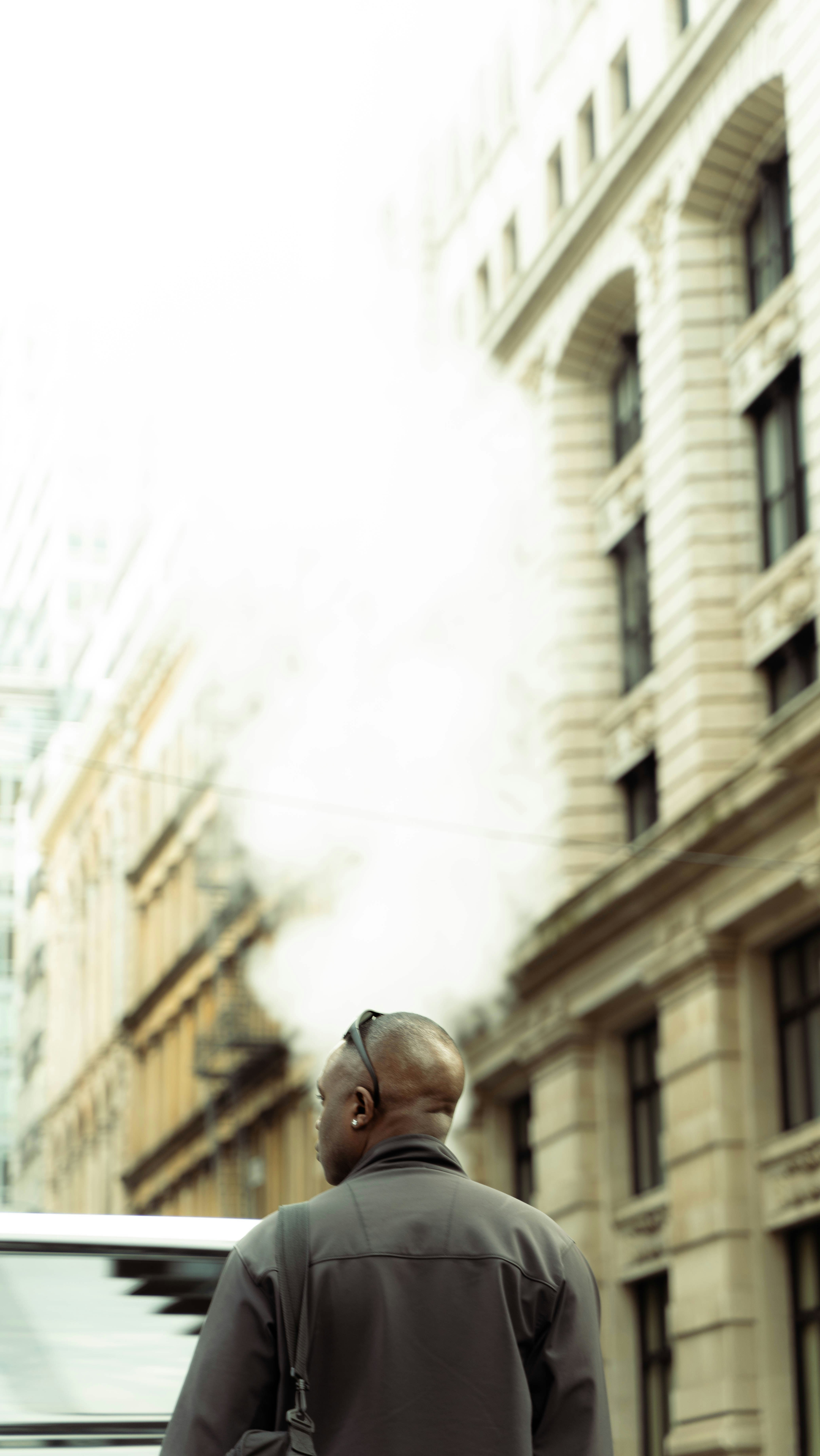 a man walking down a street next to tall buildings