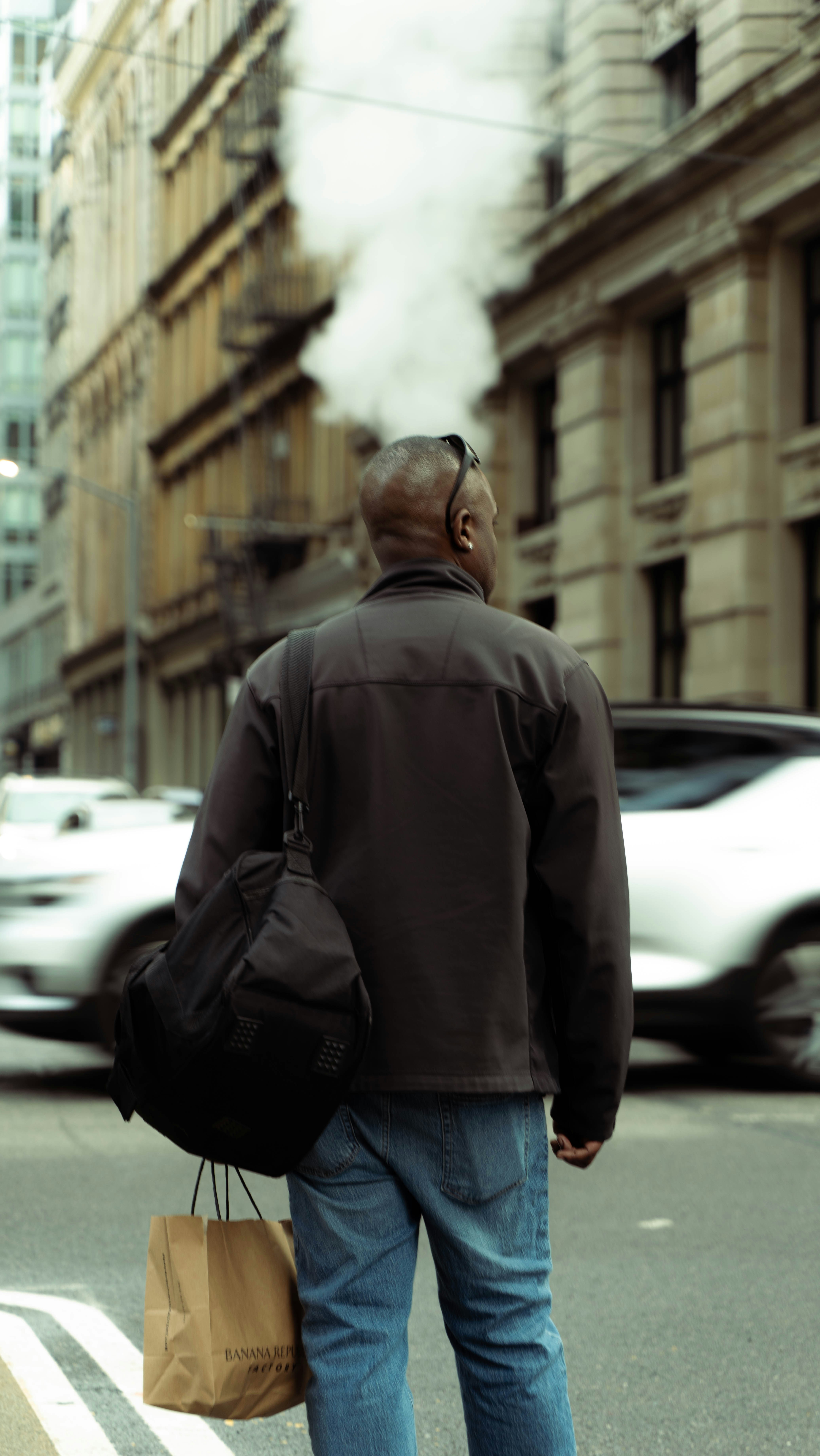 a man walking down the street carrying a bag