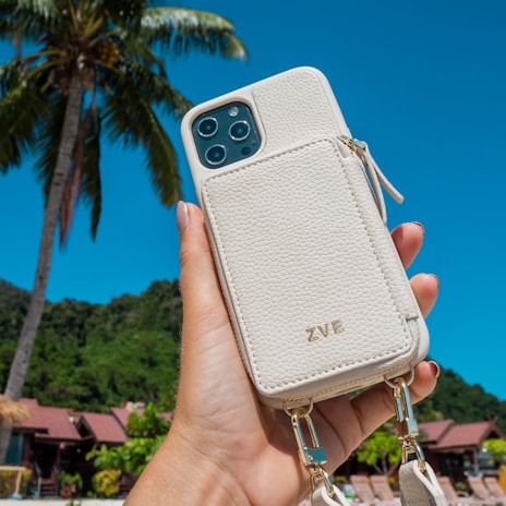 Happy customer holding their iPhone with a premium gear case, smiling outdoors.