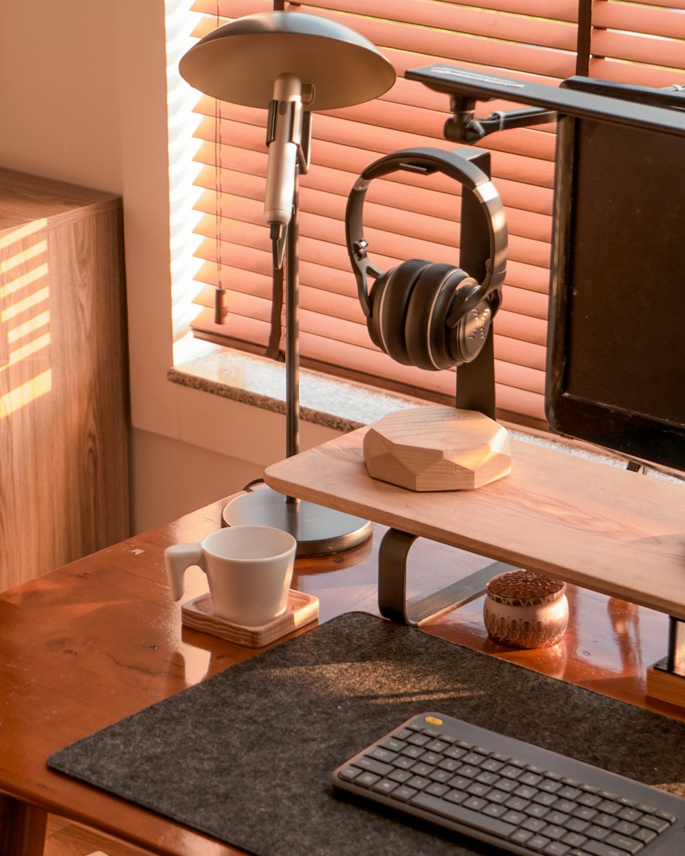 a computer desk with a keyboard, mouse and headphones