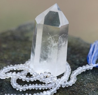 a crystal on a rock with a blue tassel