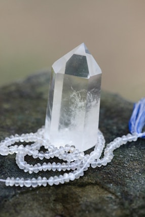a crystal on a rock with a blue tassel