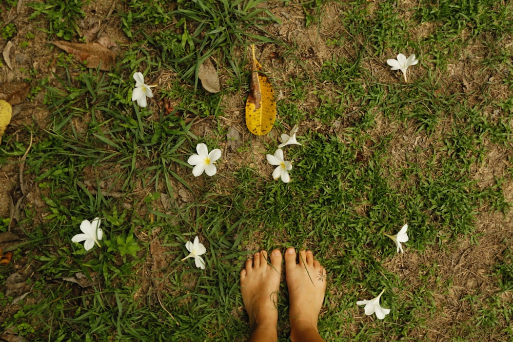 a person standing in the grass with their feet on the ground