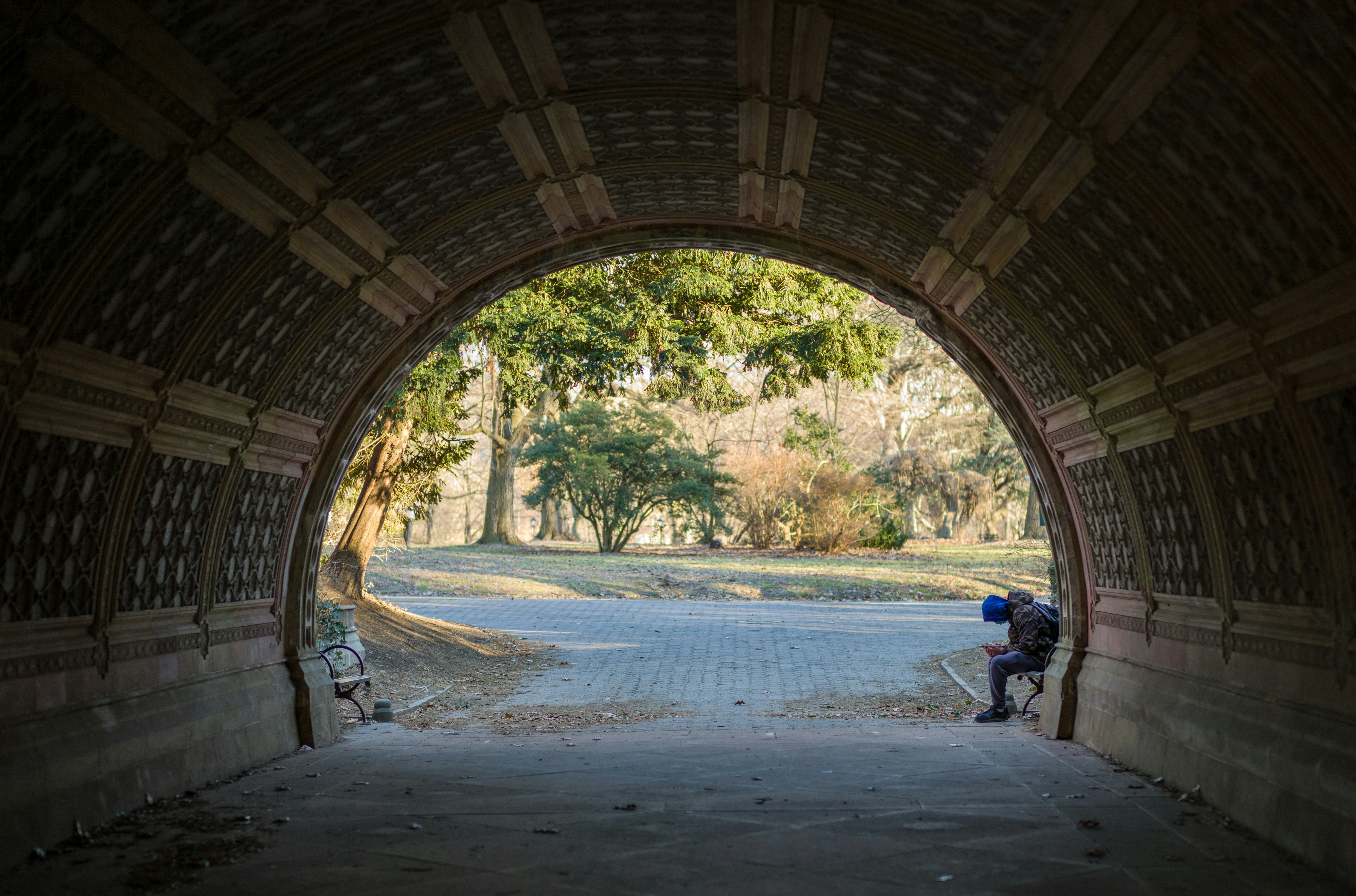 a man sitting on a bench in a tunnel