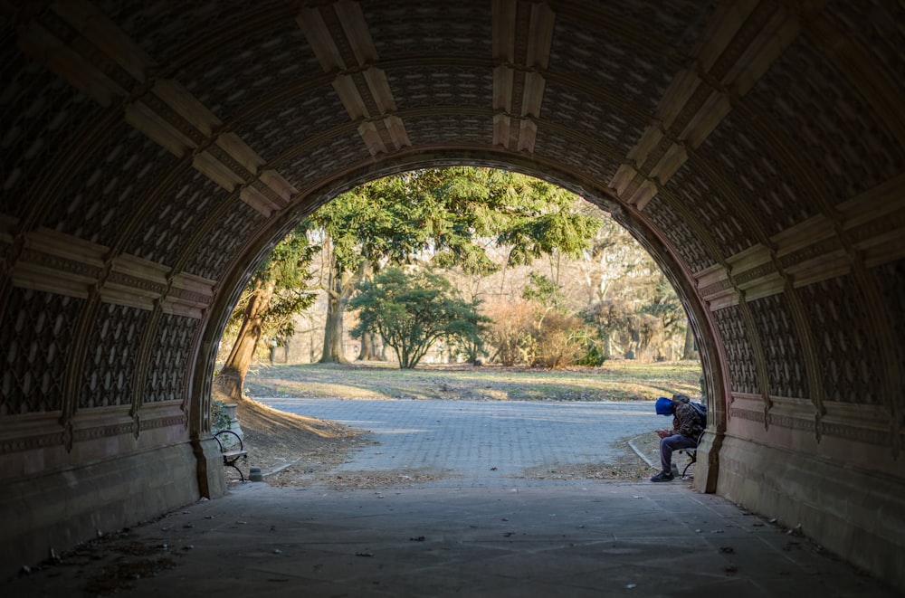 a man sitting on a bench in a tunnel