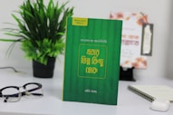 a green book sitting on top of a white table
