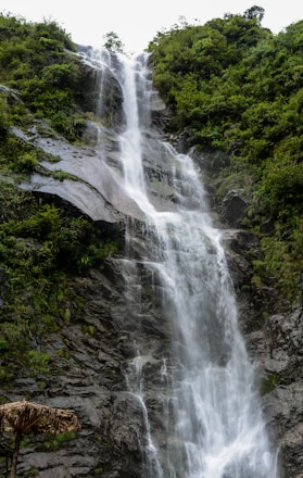 a man standing in front of a waterfall