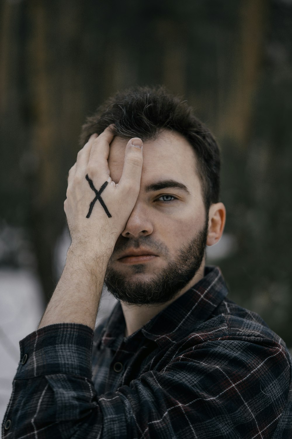 um homem com uma tatuagem de cruz na testa