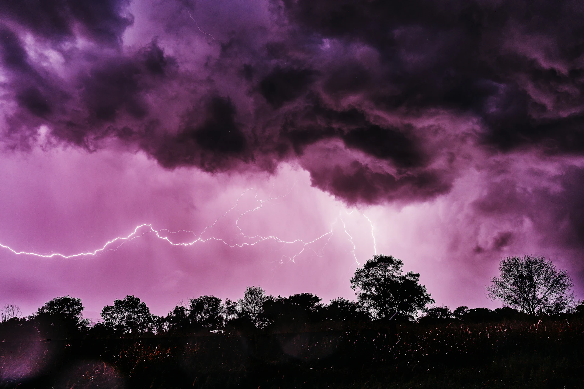 a purple sky with a lightning bolt in the distance
