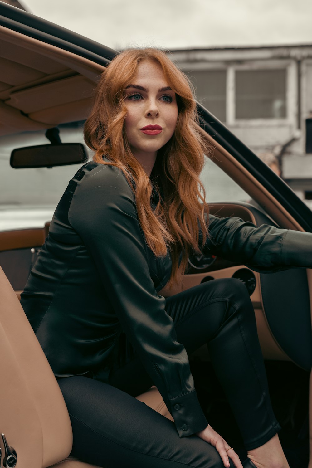 a woman sitting in the drivers seat of a car