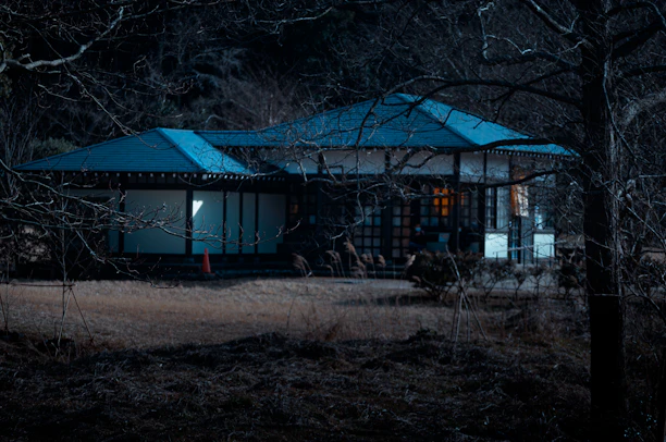 Modern Japanese house exterior with a garden at sunset
