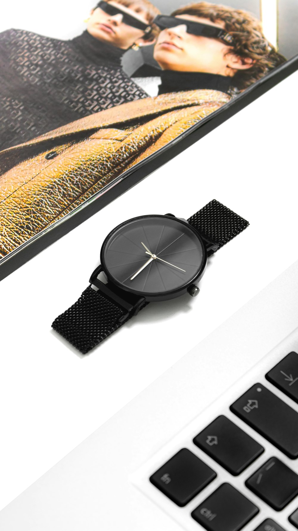 a watch sitting on top of a computer keyboard