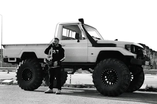 A friendly Tisler Trucking crew member answering a call beside a heavy-duty truck.