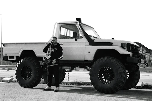 A friendly Tisler Trucking crew member answering a call beside a heavy-duty truck.