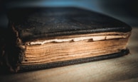 A close-up of an old, leather-bound book with a worn cover.