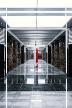 a long hallway with a red pillar in the middle of it