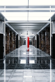 a long hallway with a red pillar in the middle of it