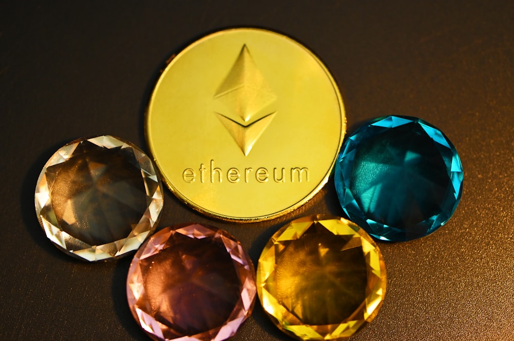three different colored diamonds next to a gold coin