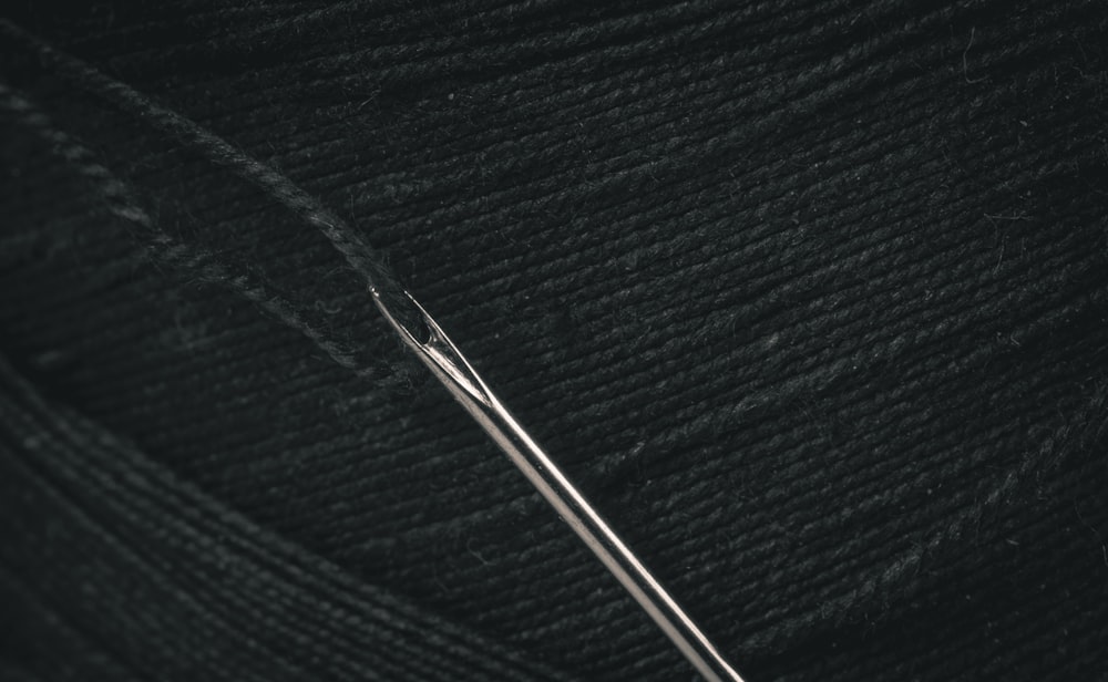 um close up de uma bola de fio com uma agulha