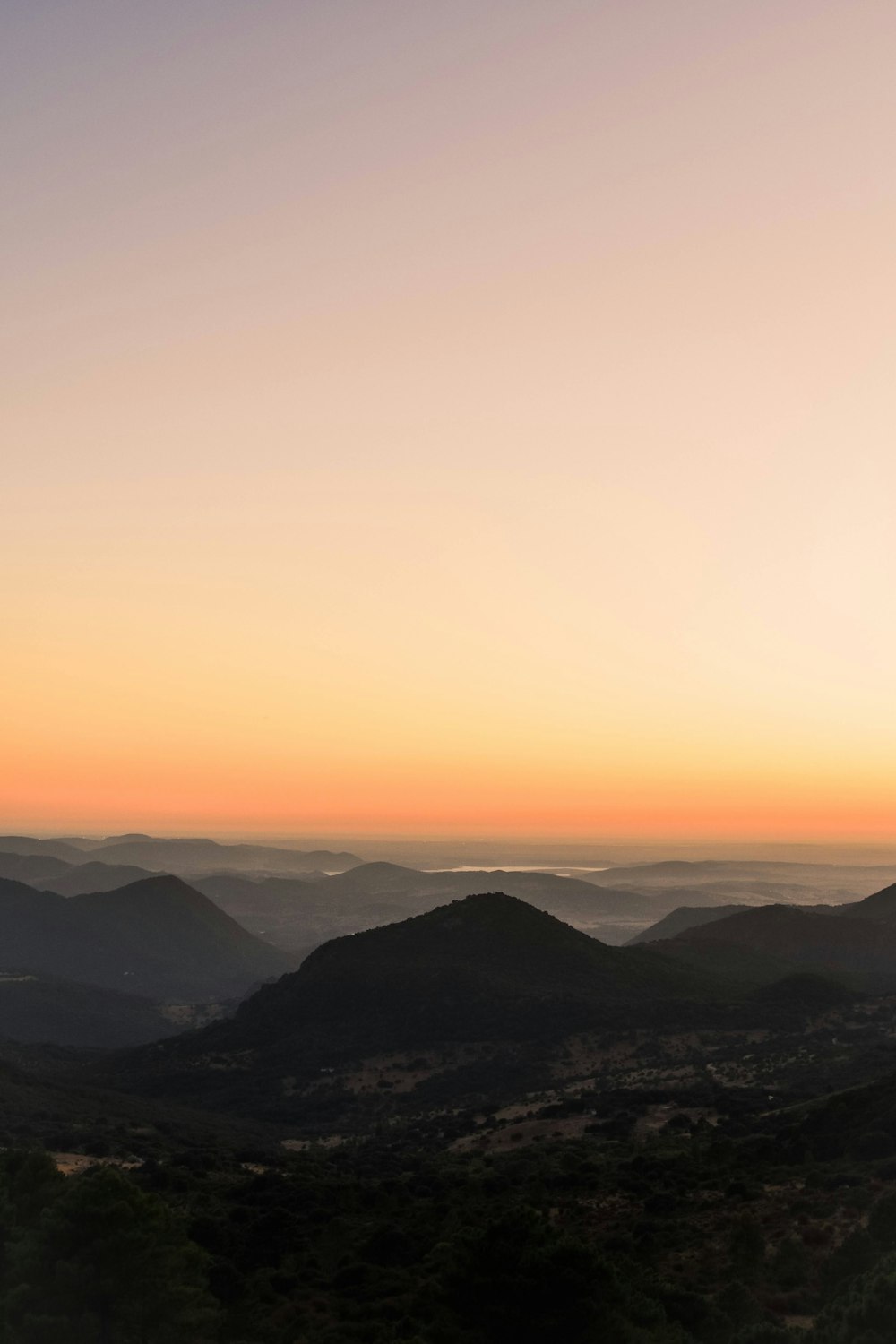 the sun is setting over a mountain range