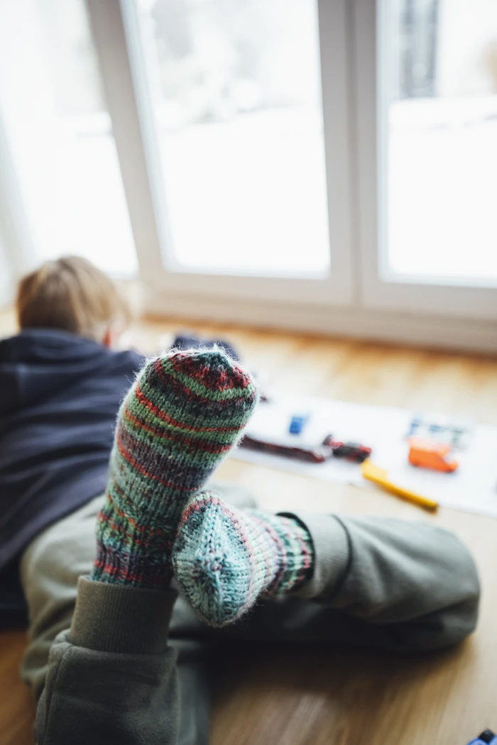 Hand-knitted multicolor wool socks worn cozily indoors