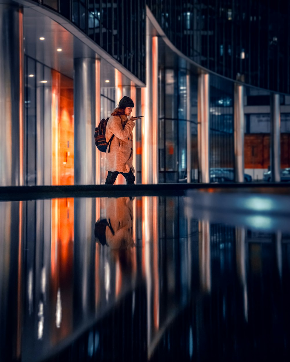 a man walking down a street next to a tall building