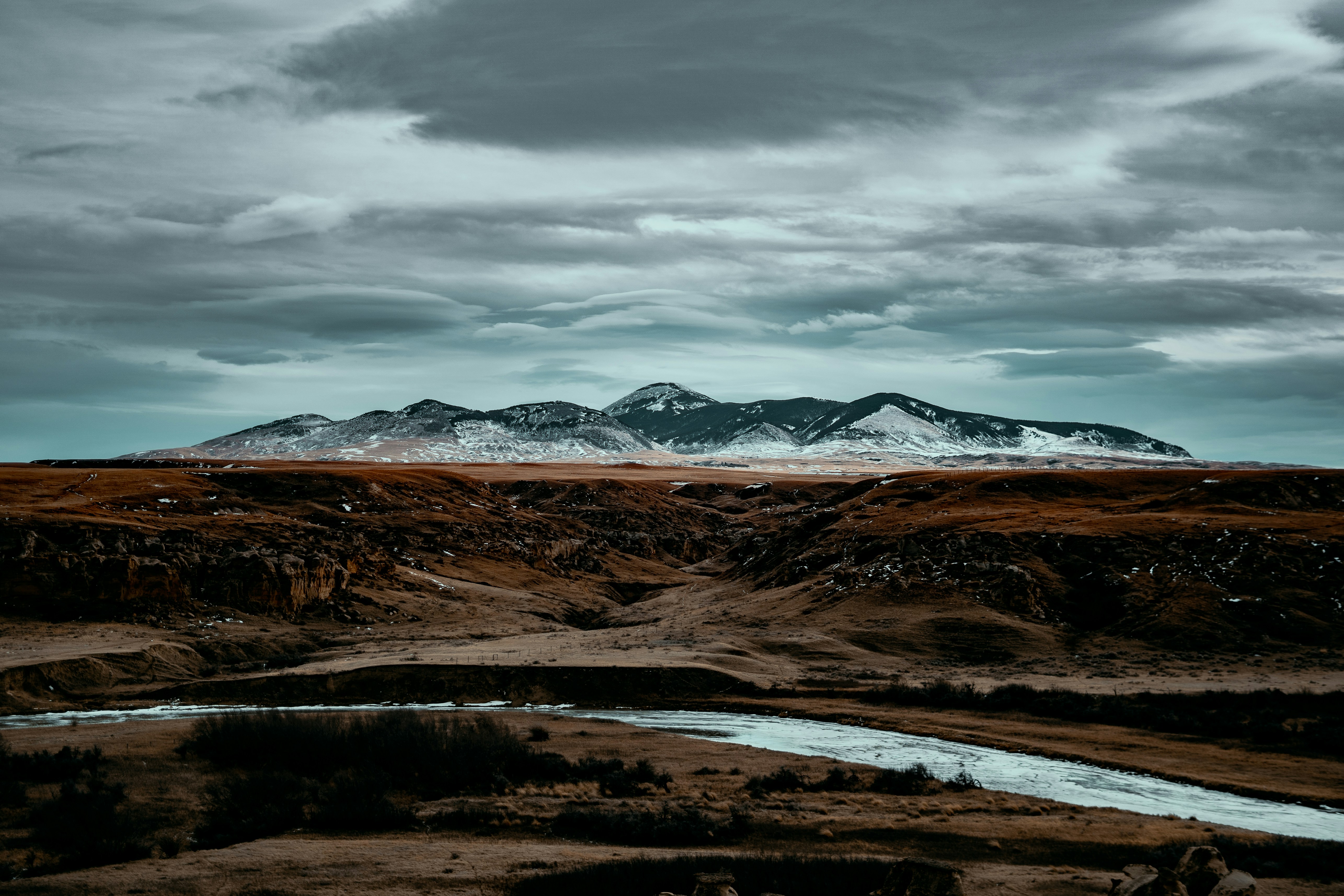 a mountain range with a river in the foreground