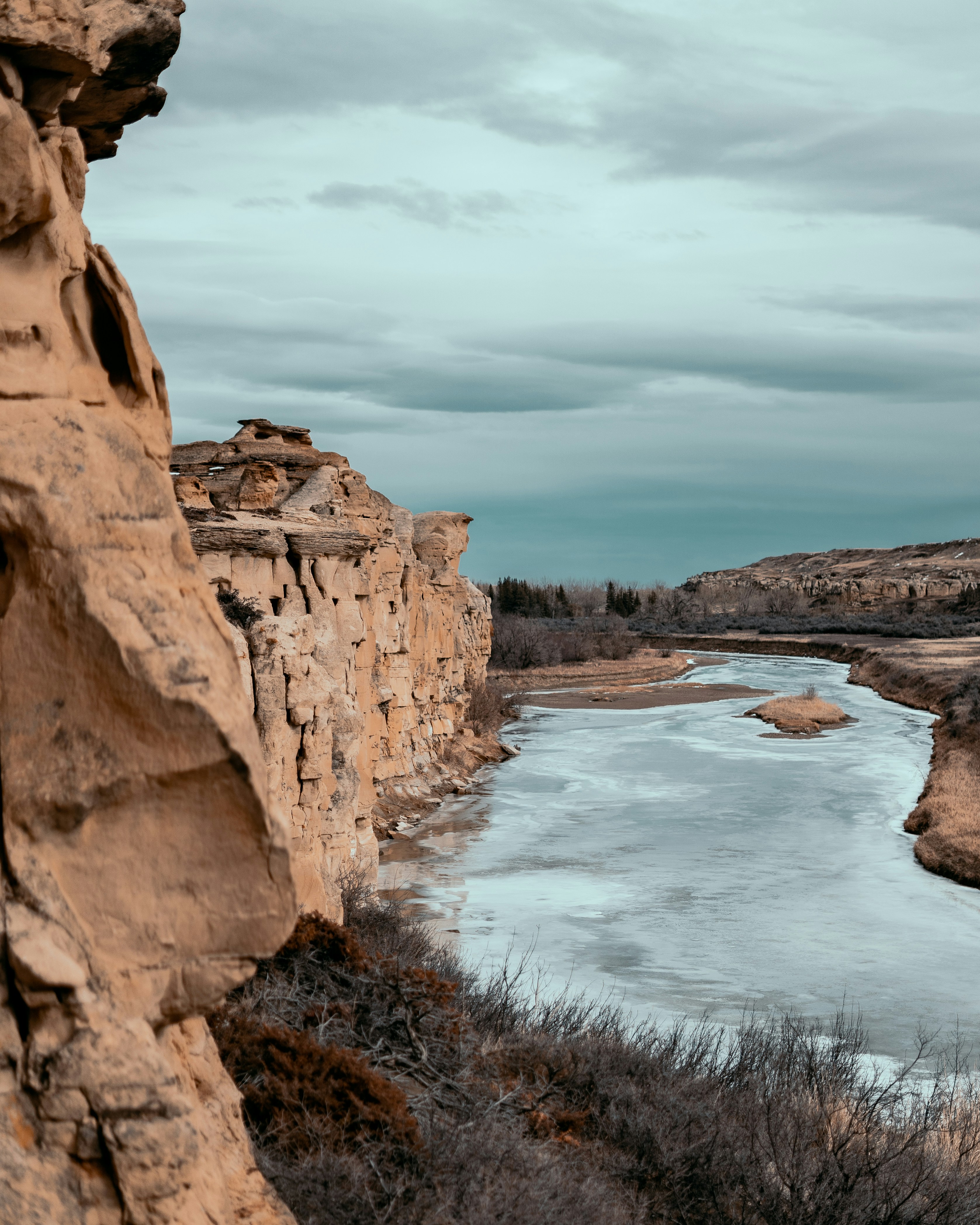 a river running through a rocky landscape under a cloudy sky