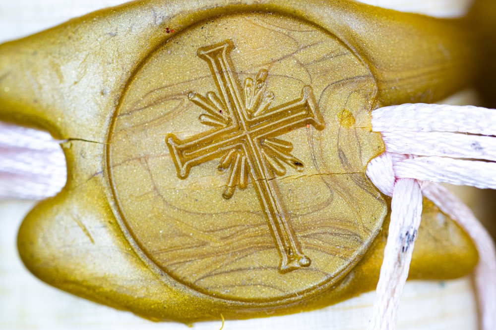 a close up of a cross on a wooden object