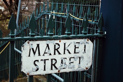 a market street sign is posted on a gate