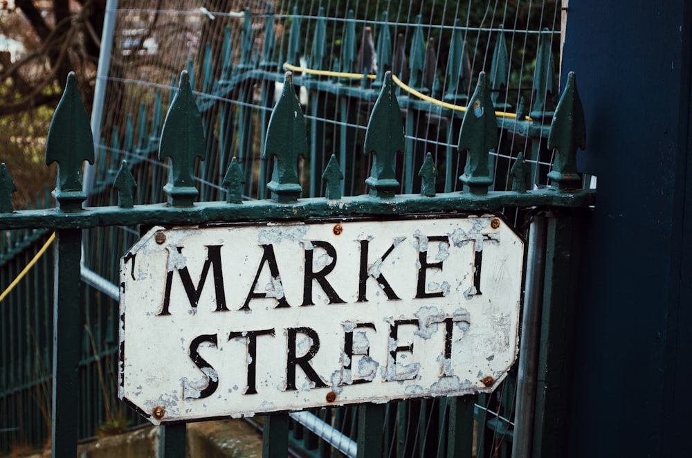 a market street sign is posted on a gate